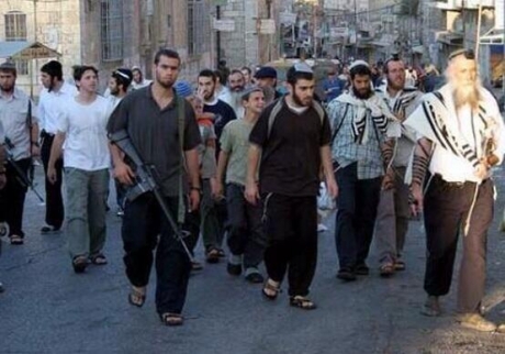 Armed Israeli settlers roaming the streets (image by Dr. Ramadhan Saeed - twitter.com)