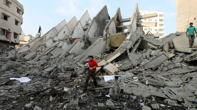 A Palestinian man walks in front of the remains of a tower building housing offices, which witnesses said was destroyed by an Israeli air strike, in Gaza City August 26, 2014.(Reuters / Mohammed Salem)