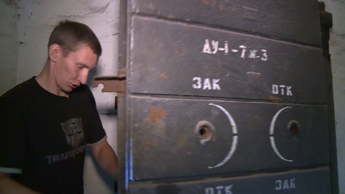 Vadim Streltsov, local resident, opens a door to the bomb shelter, Lugansk, eastern Ukraine (screenshot from RT video)