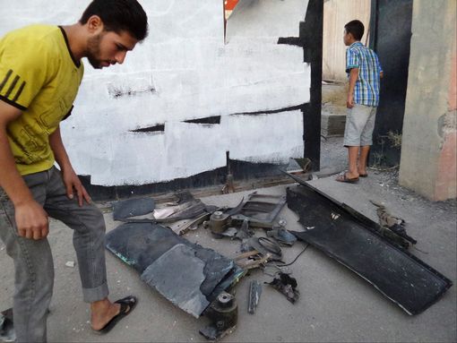 Attacks: A man inspects the remains of what ISIS claims was a US drone in Raqqa Attacks: A man inspects the remains of what ISIS claims was a US drone in Raqqa
