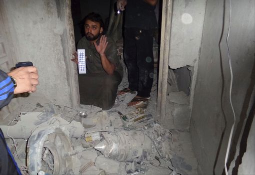 A man inspects the damage in a communication station where Islamist State militants say a U.S. drone crashed into in Raqqa September 23, 2014.