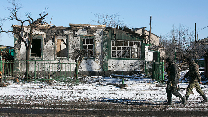 Rebels walk near a building damaged during fighting in the village of Nikishine, south east of Debaltsevo February 17, 2015 (Reuters / Baz Ratner)