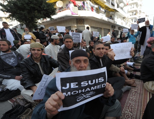 A demonstrator holds up a "Je Suis Muhammad" sign during the Friday prayers to protest against the cartoons published in French magazine Charlie Hebdo in Algiers, Algeria, Friday, Jan. 16, 2015. Algerian police are struggling to contain more than a thousand protesters thronging the streets of the capital denouncing cartoons of the Prophet Muhammad published by French satirical weekly Charlie Hebdo. Chanting "I am not Charlie, I am Muhammad," protesters left their mosques after Friday prayers and gathered in downtown Algiers' May 1 square where they were met by hundreds of riot police. (AP Photo/Sidali Djarboub)
