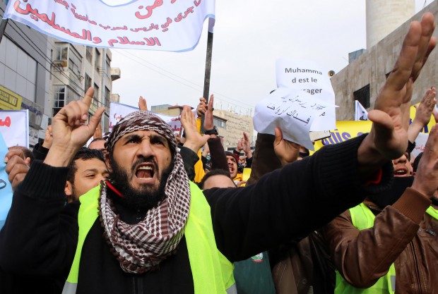 A Jordanian chants slogans during a protest against cartoons depicting the Prophet Muhammad in the French satirical magazine Charlie Hebdo, after Friday prayers in Amman, Friday, Jan. 16, 2015. A rally by Pakistani students against a French satirical weekly's latest publication of a Prophet Muhammad cartoon turned violent on Friday, with police firing warning shots and water cannons to disperse the demonstration. A photographer with the Agence France-Presse was shot and wounded in the melee. But although there were concerns that rallies against Charlie Hebdo' new cover depicting the prophet ? an act deemed insulting to many followers of Islam ? would unravel into violence across the Muslim world, most of the protests elsewhere passed peacefully. (AP Photo/Raad Adayleh)