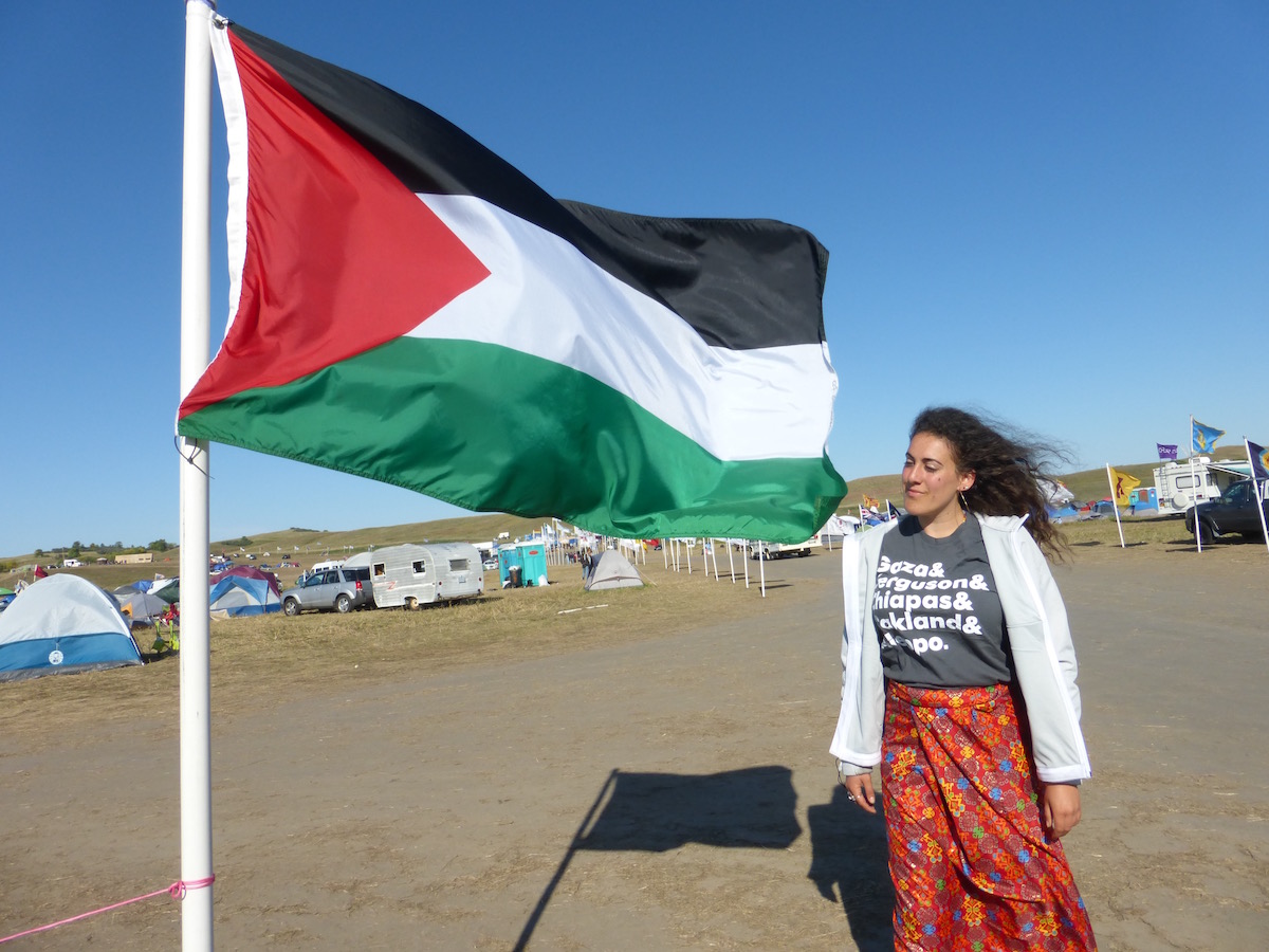The author standing by the Palestinian flag in Oceti Sakowin Camp