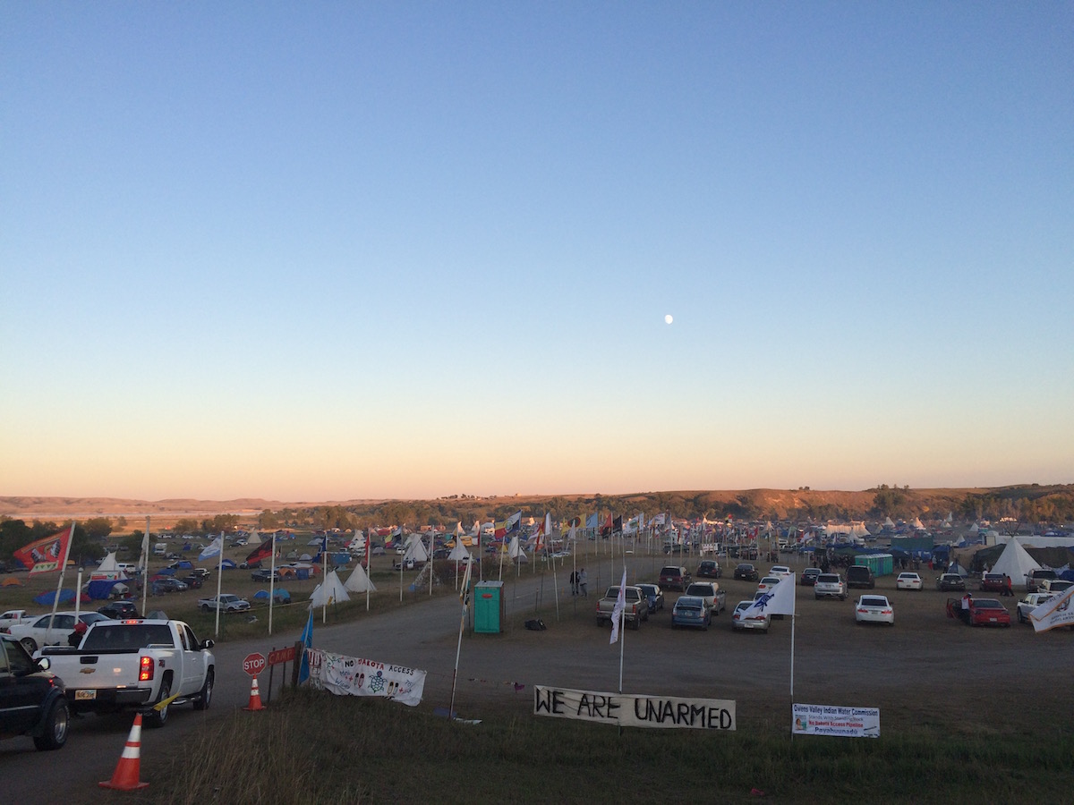 "We Are Unarmed" banner at the mouth of Oceti Sakowin/Red Warrior Camp (Photo: Nadya Tannous)