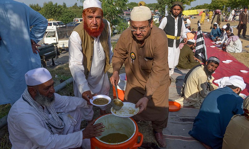 Opposition activists look on as they distribute food during the 'Azadi March' in Islamabad on November 3, 2019. — AFP
